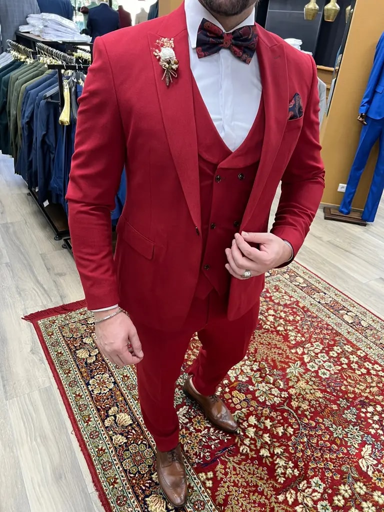 Homme portant un costume rouge élégant avec nœud papillon