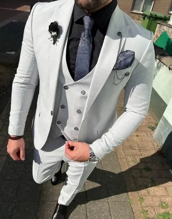 Homme en costume trois pièces blanc avec cravate noire