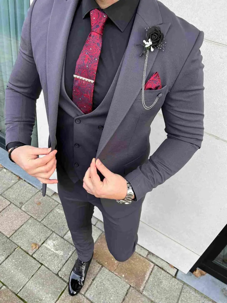 Homme en costume gris avec cravate rouge et fleur noire