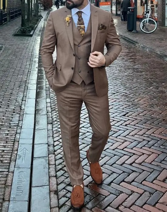 Homme en costume marron élégant marchant dans la rue