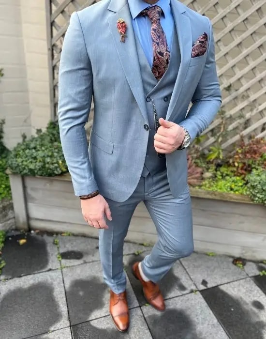 Homme en costume bleu clair avec cravate et pochette