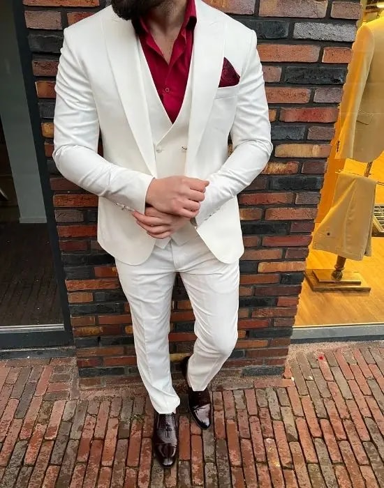 Homme en costume blanc avec chemise rouge