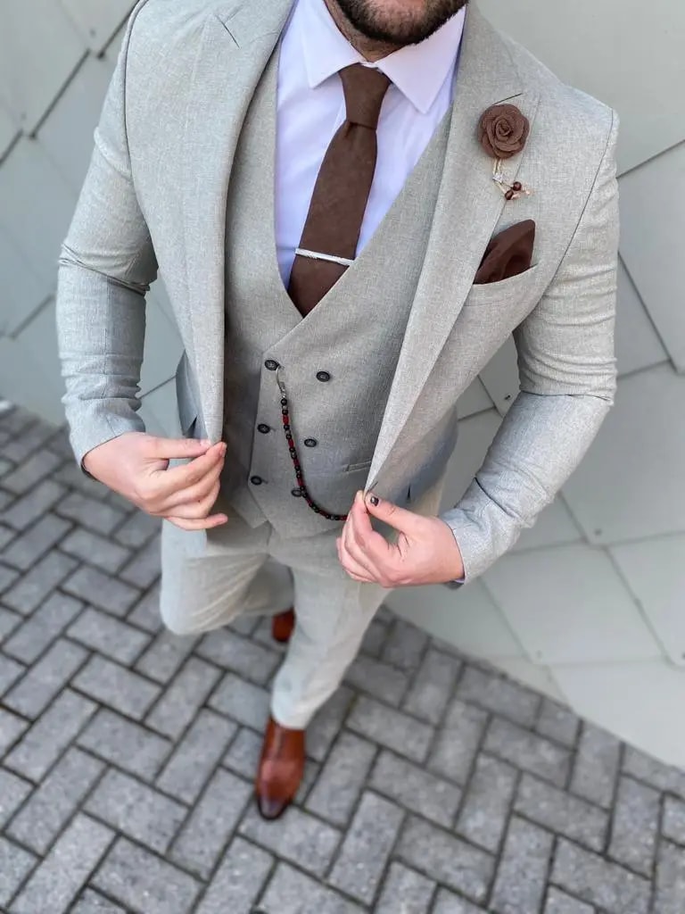 Homme en costume gris clair avec cravate marron