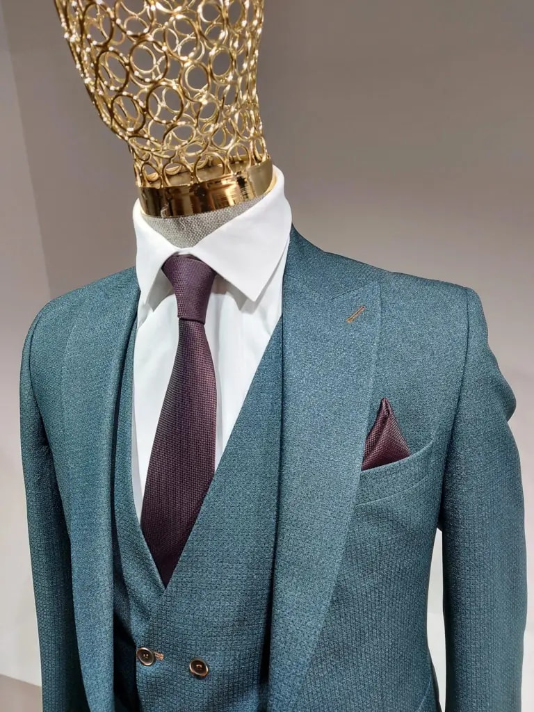 Costume bleu avec cravate bordeaux sur mannequin doré