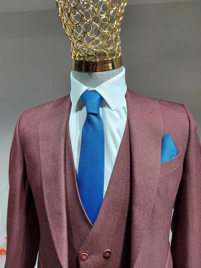 Costume bordeaux avec cravate bleue et chemise blanche