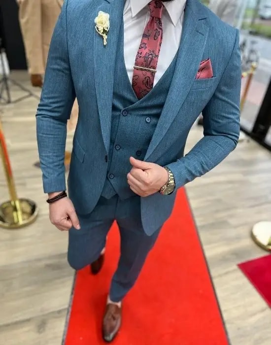 Homme en costume bleu sur tapis rouge